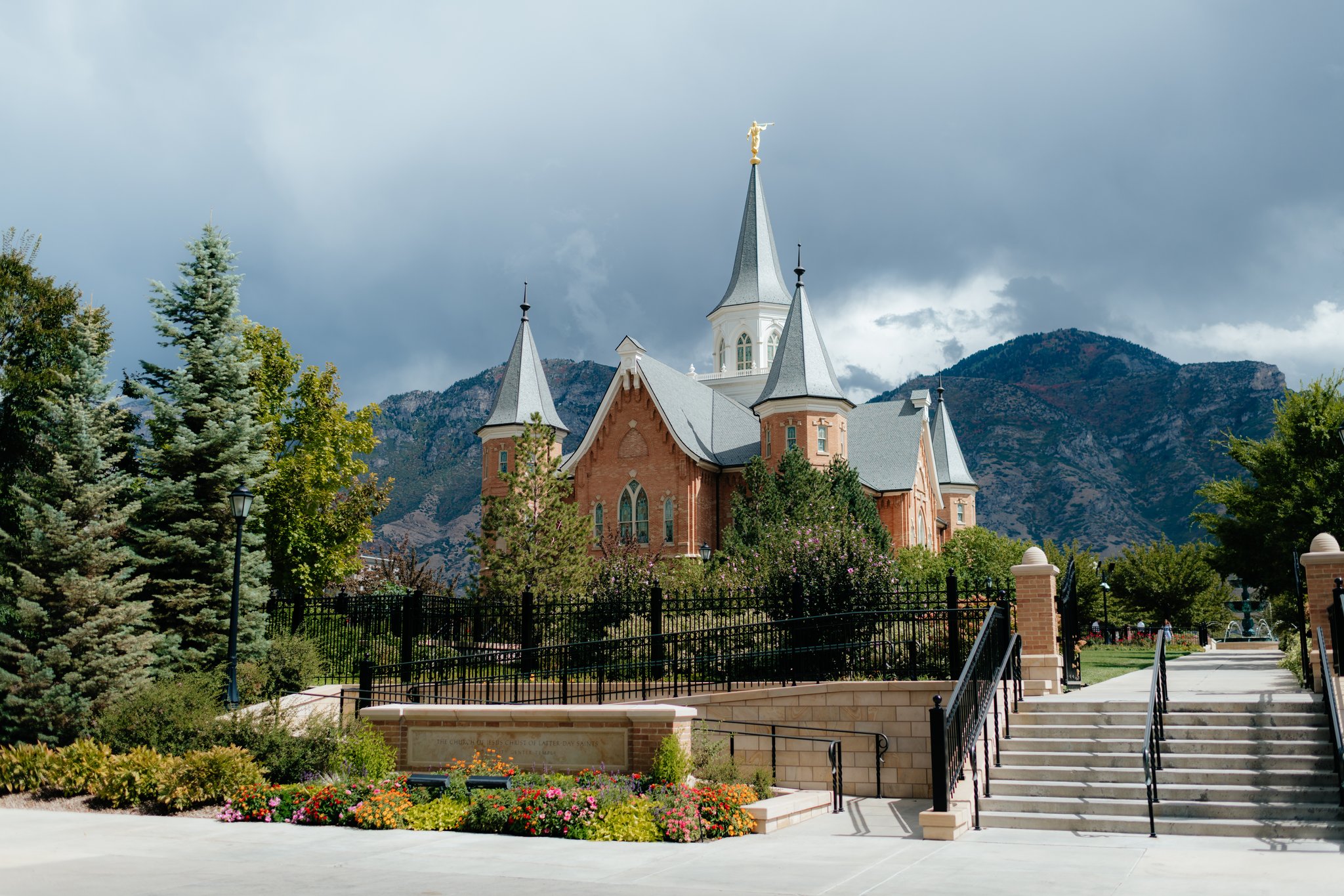 Provo City Center Temple exterior from the west side with dark storm clouds overhead in september, photographed by utah temple photographer sarah mismash