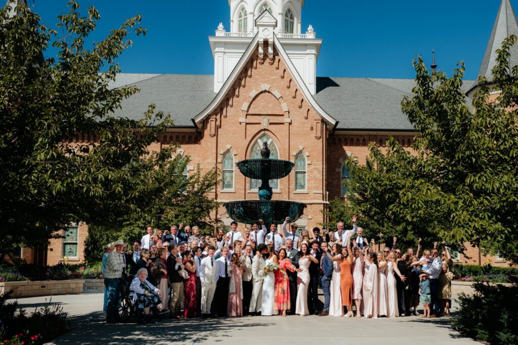 The extended family gathers for a group portrait on the temple lawn after a September wedding at the Provo City Center Temple.
