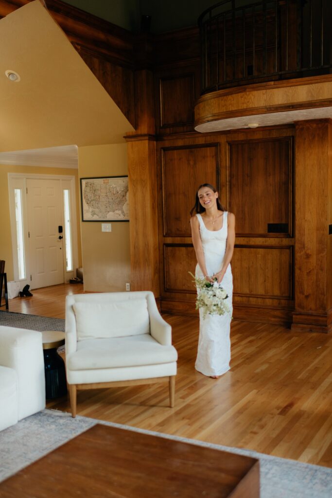 The bride steps into the room for a first look before her September wedding in provo, utah