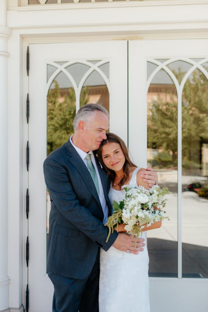 Bride and her father posing in front of temple doors at the provo city center temple on a september afternoon