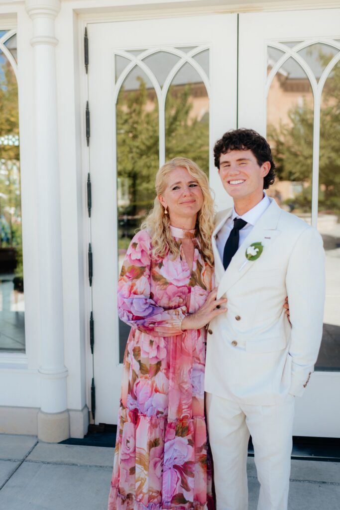 groom and his mother posing in front of temple doors at the provo city center temple on a september afternoon