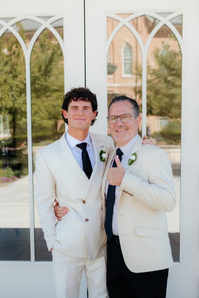 groom and his father posing in front of temple doors at the provo city center temple on a september afternoon