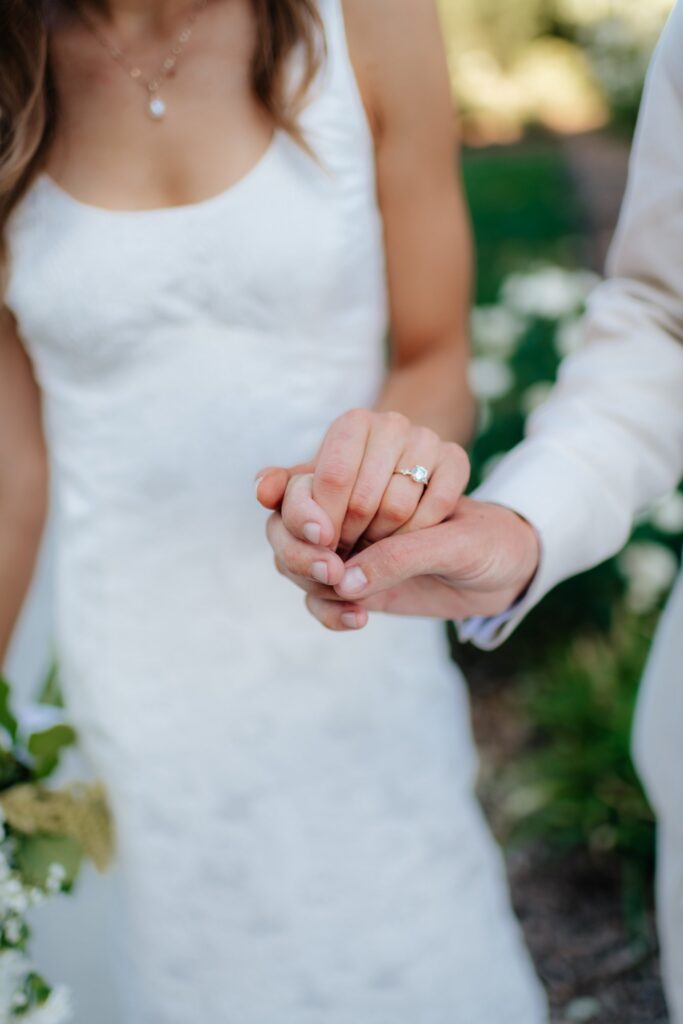 A close-up of the couple's clasped hands and wedding ring after their ceremony at the Provo City Center Temple.