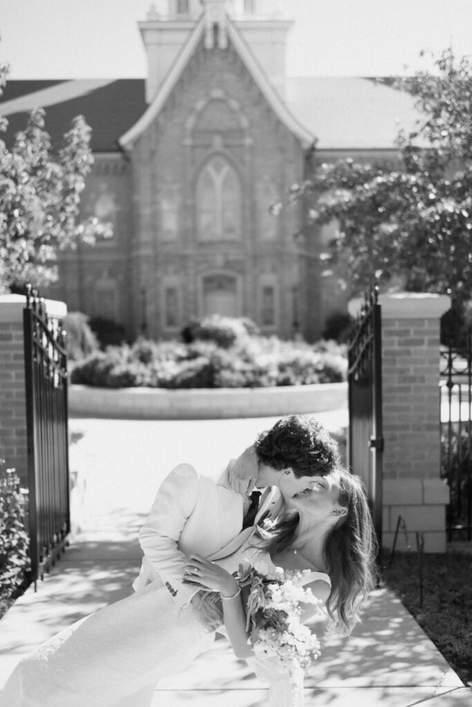 a couple kisses outside the gates of the provo city center temple