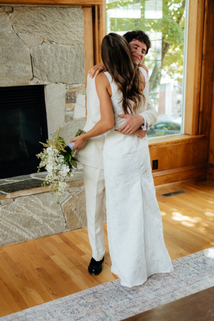 The couple embraces during their first look by the fireplace, photographed by utah temple wedding photographer sarah mismash