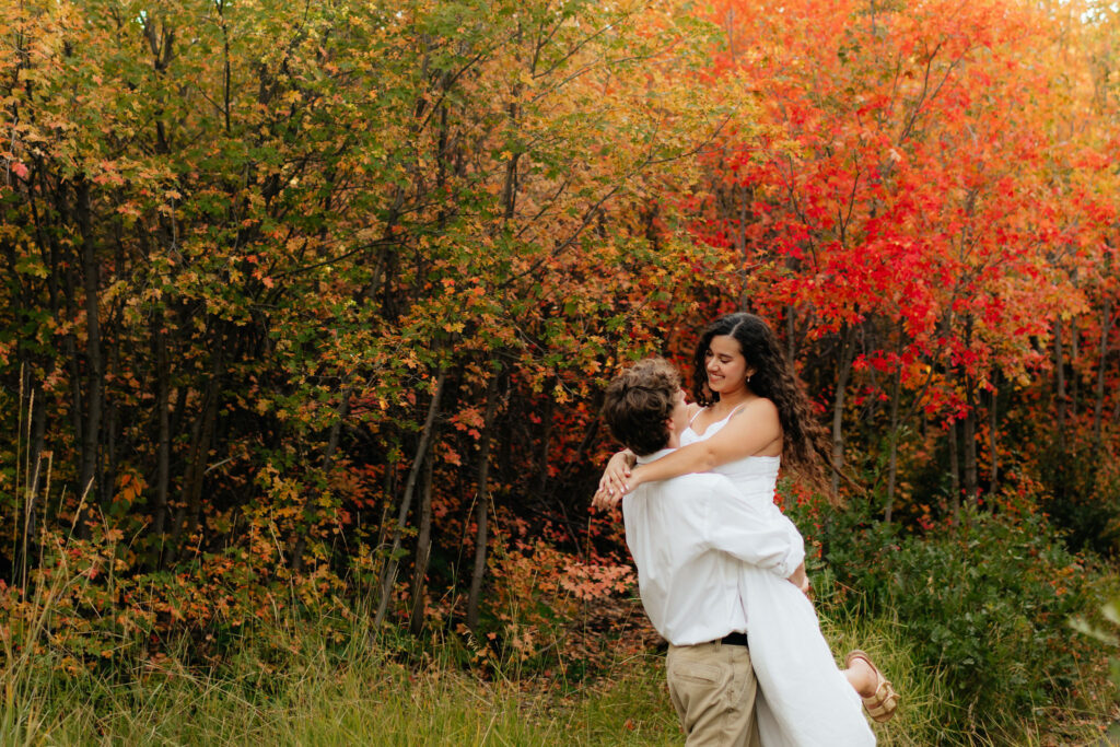 a couple spins during their fall engagement photos on the alpine loop in american fork canyon, utah, with engagement photographer sarah mismash