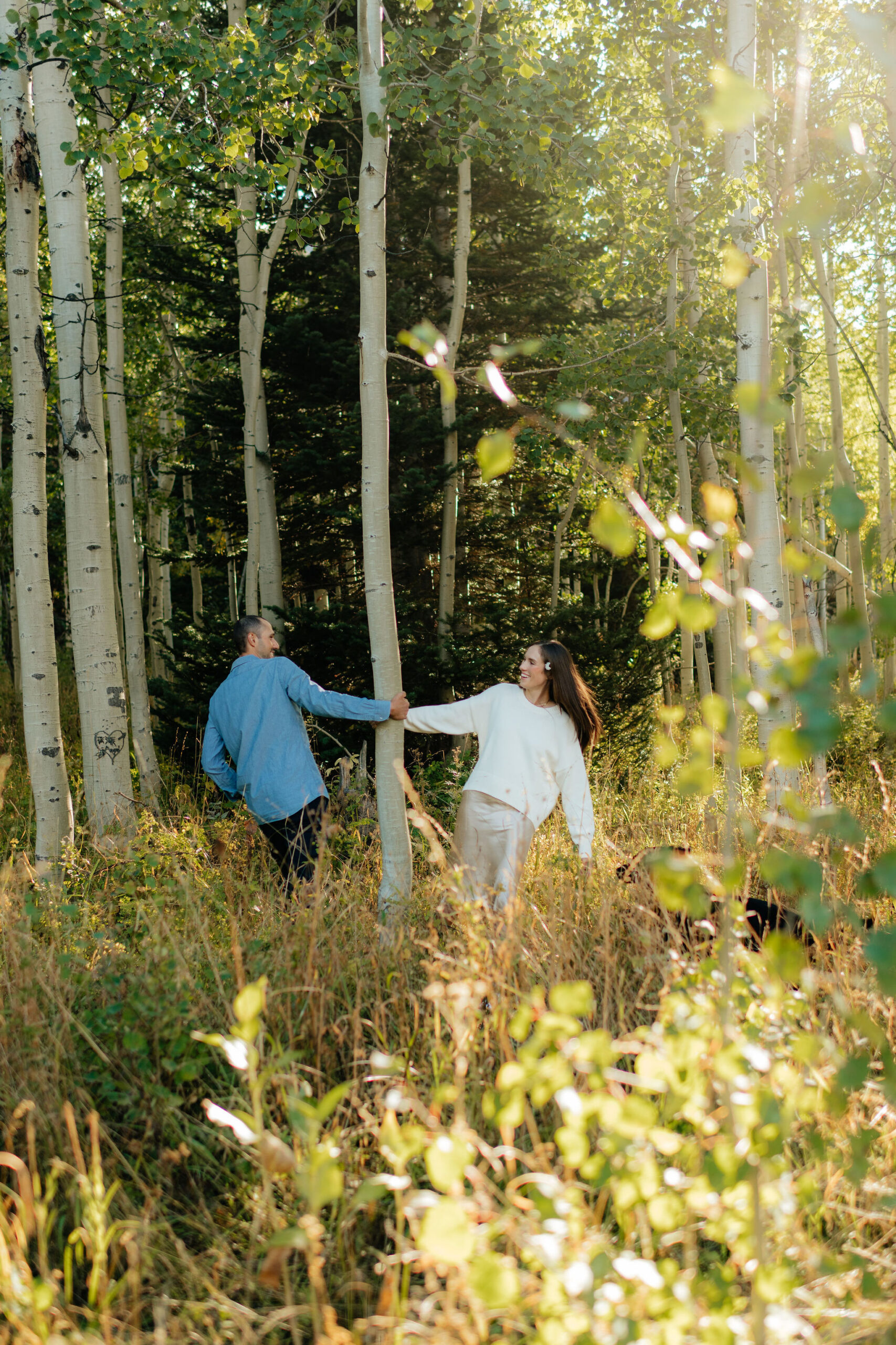 a couple dances in the aspens during their fall engagement photos on the alpine loop