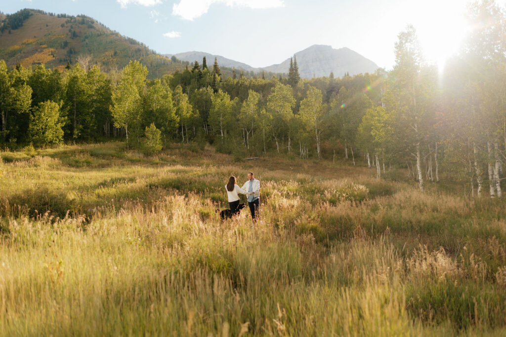 a couple runs through a field during their fall engagement photos in the aspens with utah engagement photographer sarah mismash