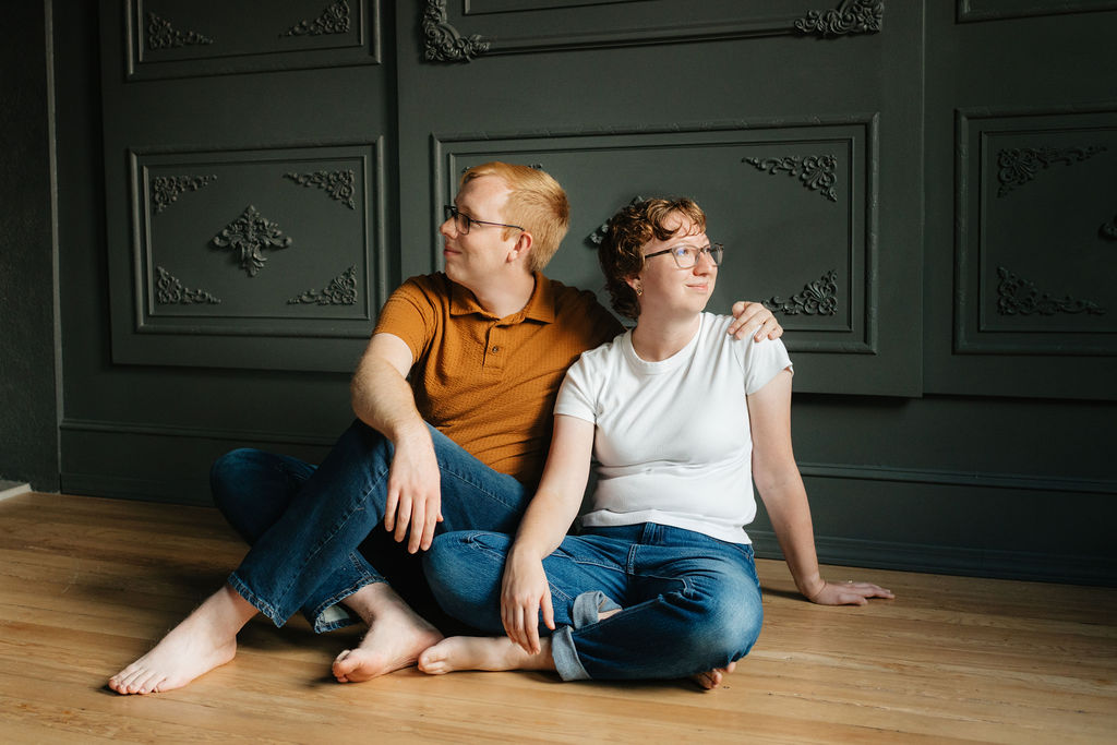 a couple smiles together in the conservatory of the brightwood house studio in provo utah