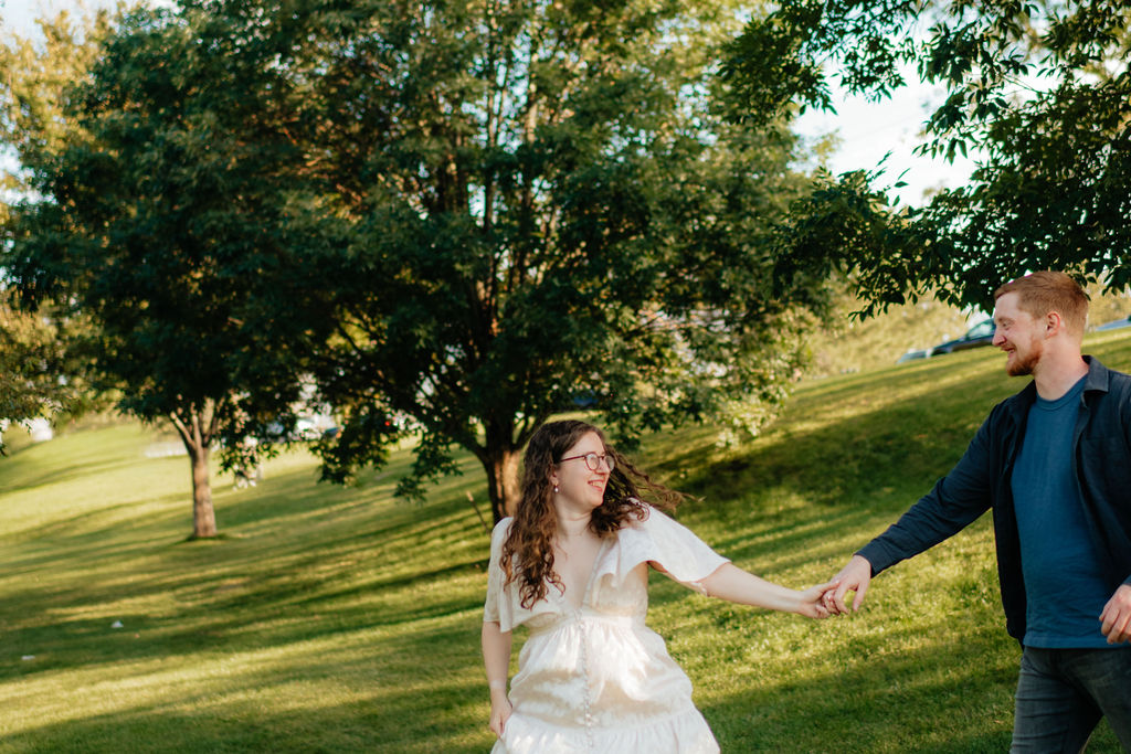 a couple runs through sugarhouse park during their engagement photos in SLC