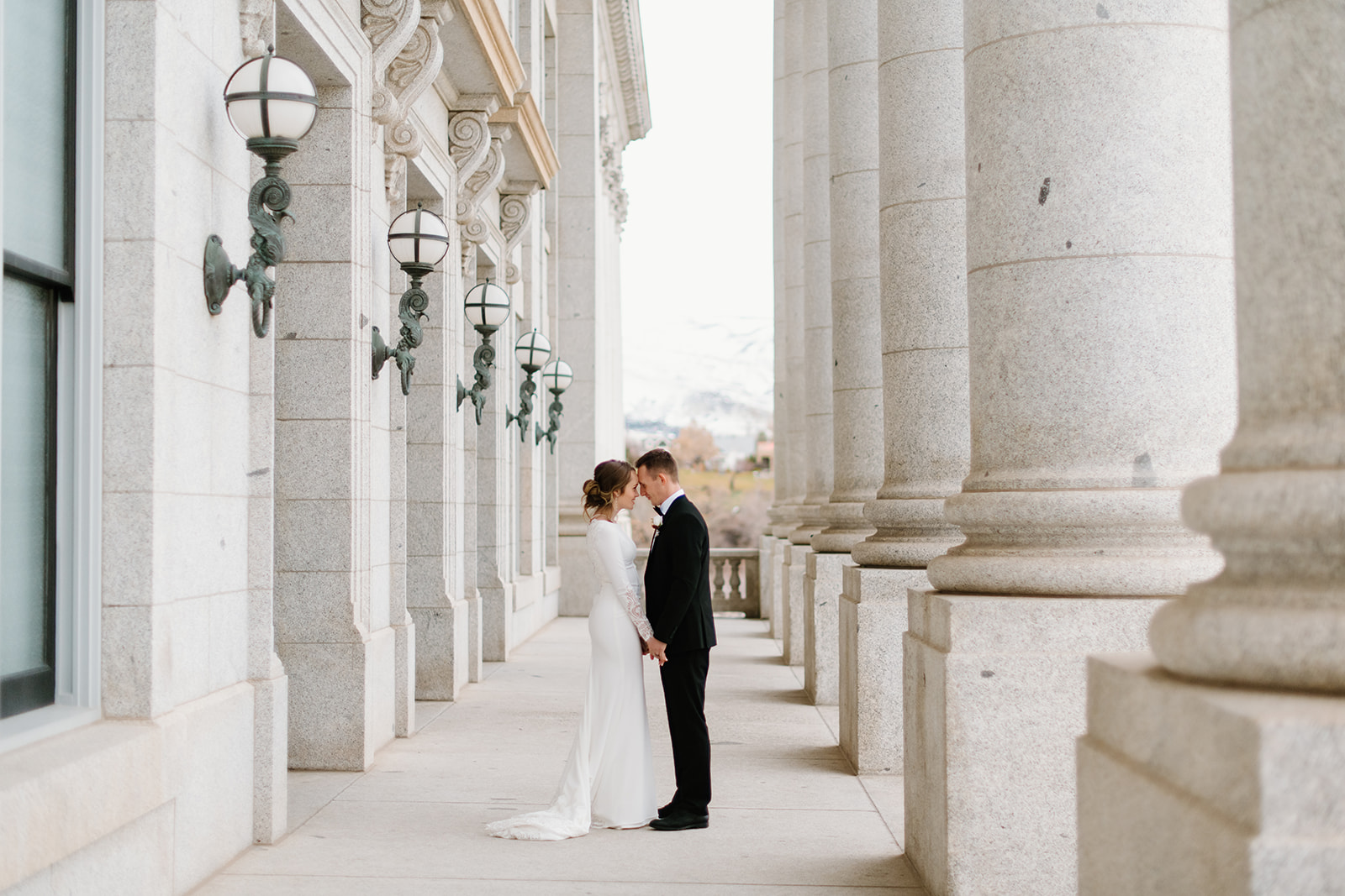 a couple pauses together for a quiet moment during their winter wedding photos at the utah state capitol