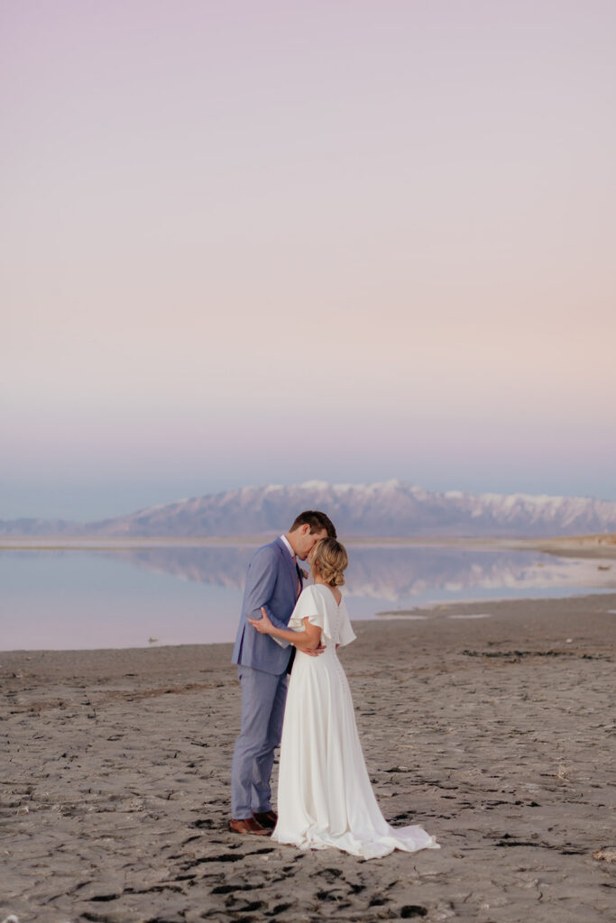 a couple during a january bridal wedding portrait session at antelope island, photographed by utah snowy wedding photographer sarah mismash