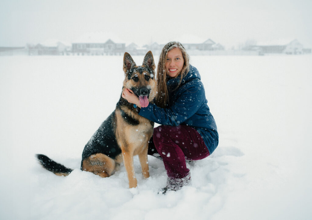 photo of utah winter storm waitlist snowy engagement and wedding photos photographer sarah mismash, knee deep in falling snow with her dog